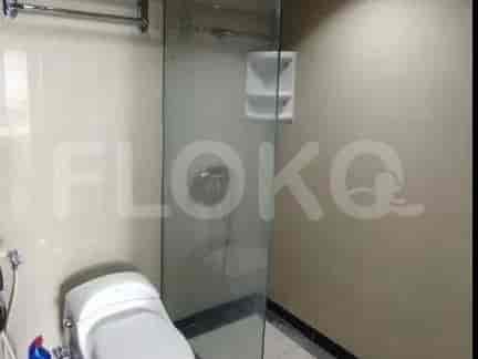 A bathroom with a toilet and a glass-enclosed shower.