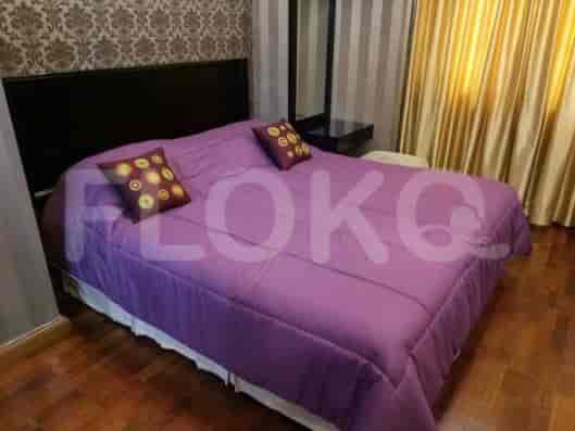 A bedroom with a large purple comforter on a queen-size bed, and decorative pillows.