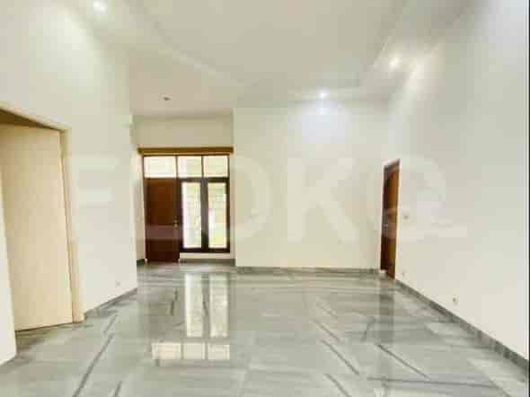 A spacious room with marble flooring and light-colored walls, featuring doorways and windows.