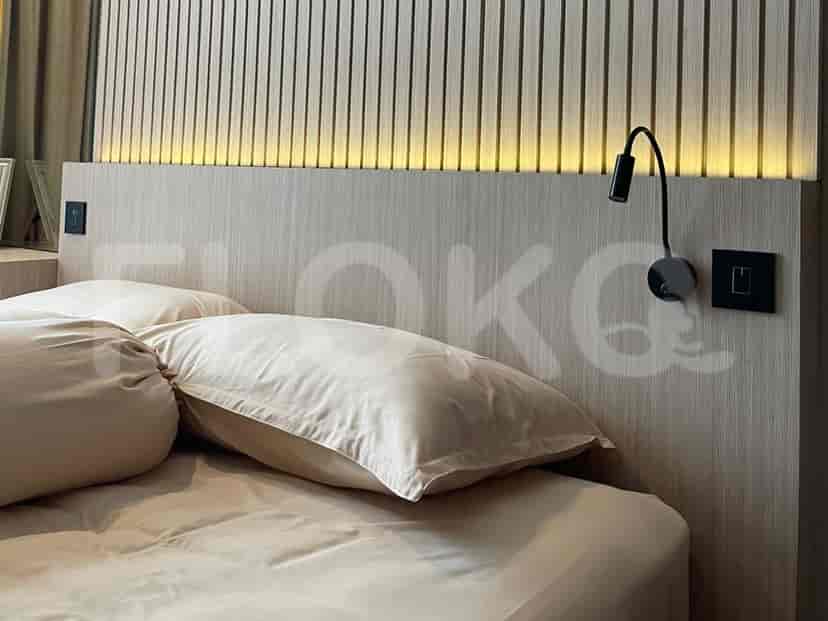 Cozy bedroom with a bed and bedside lamp.
