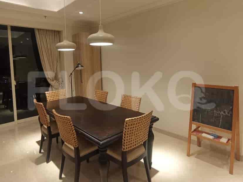 A dining room with a wooden table, chairs, and two pendant lights.