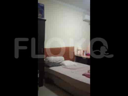 A bedroom featuring a bed with a wooden headboard, wardrobe, and air conditioning unit.