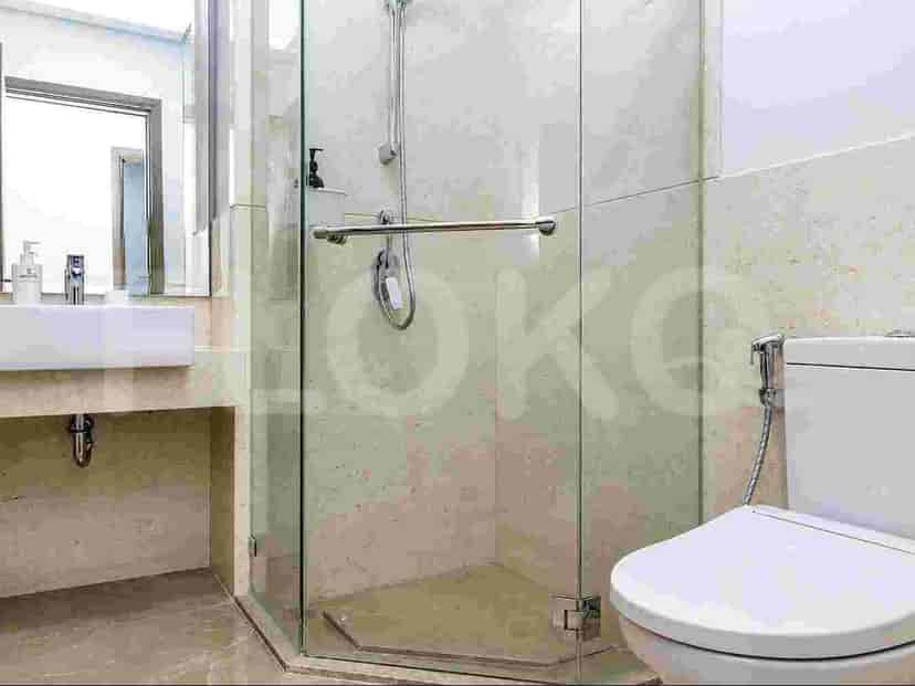 A modern bathroom with a glass-enclosed shower, a toilet, and a vanity with a sink.