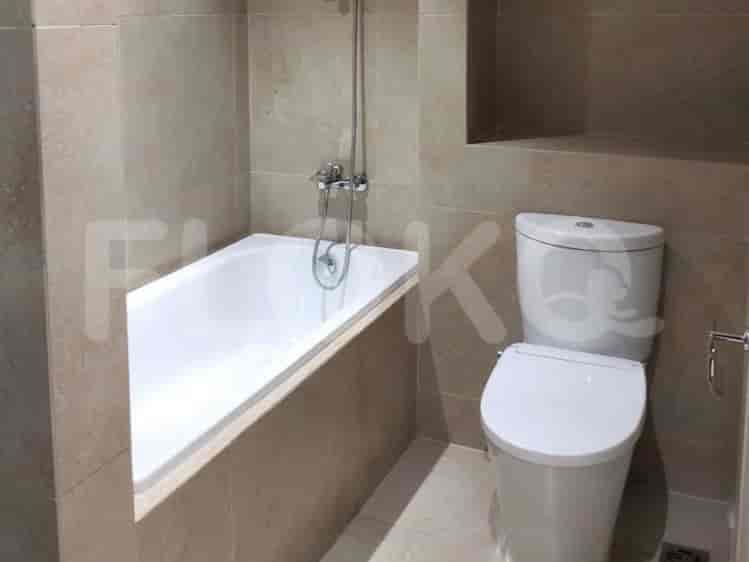 Kamar mandi dengan bak mandi, toilet, dan dinding berubin.
