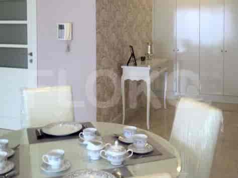 A bedroom with a queen-size bed, side tables, and a large window with blue curtains.