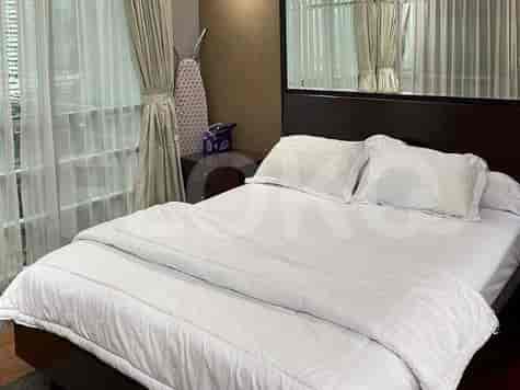 A bedroom with a bed, curtains, and a window.