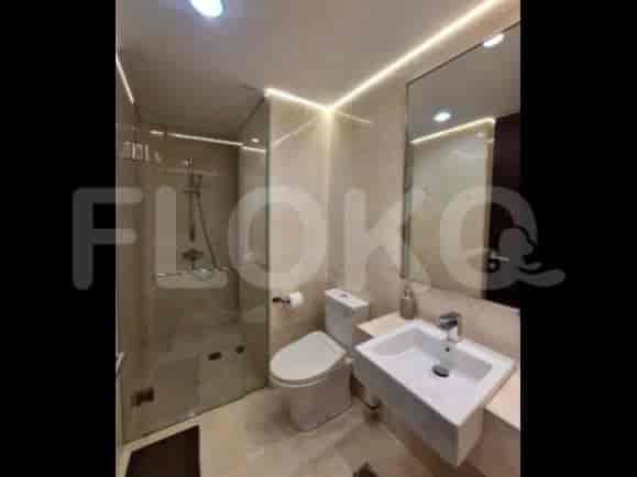 A modern bathroom with a shower, toilet, and sink.