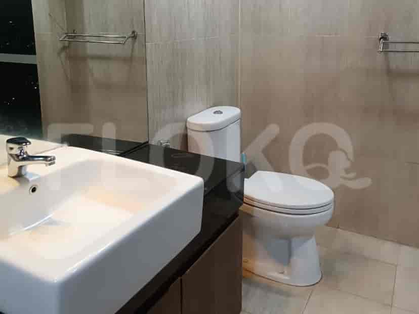 A modern bathroom with a sink, toilet, and tiled walls.