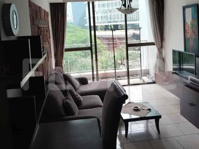 A living room with a grey L-shaped sofa, large windows, and modern decor.