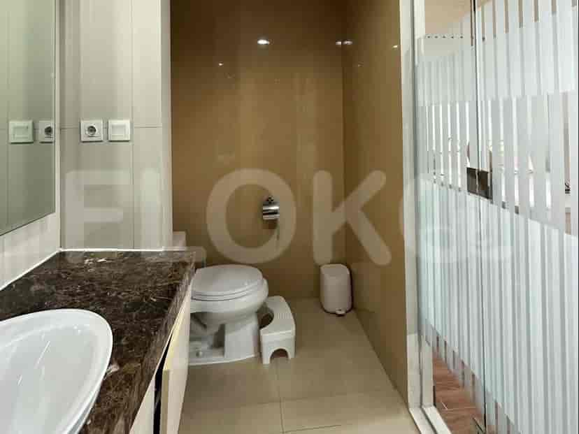 A bathroom with a toilet, sink, and frosted glass shower.