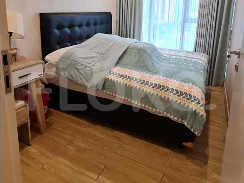 Kamar tidur dengan tempat tidur ukuran queen, meja samping tempat tidur, dan jendela besar dengan tirai.