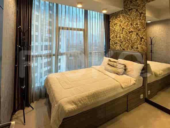 Sebuah kamar tidur dengan tempat tidur ukuran queen, wallpaper bermotif, jendela besar dengan gorden, dan cermin.