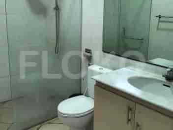 A bathroom featuring a toilet, a glass-enclosed shower, and a vanity with a marble countertop and sink.