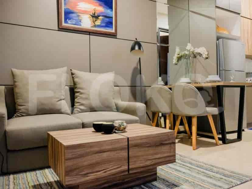 A living room with a sofa, coffee table, and a painting on the wall.