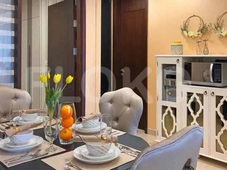 A dining room table set for a meal, with chairs and a sideboard.