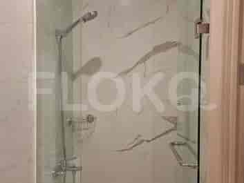 A shower area with a glass door, chrome fixtures, and a handheld showerhead.