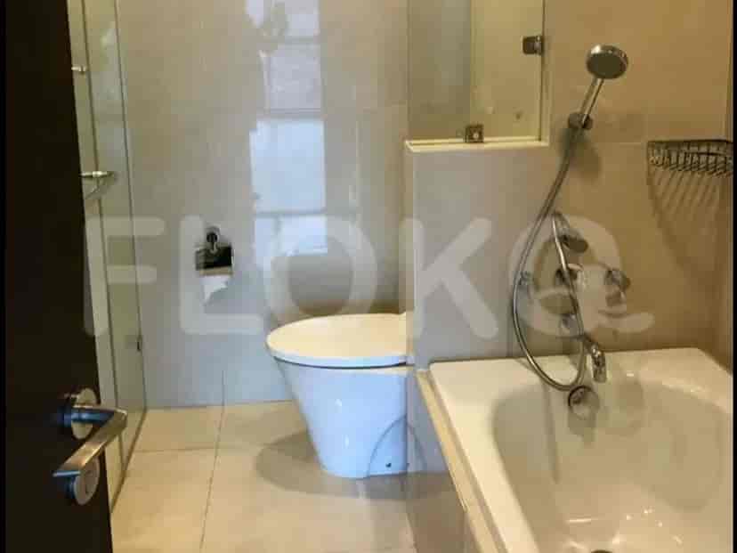 Kamar mandi kontemporer dengan bak mandi, toilet, dan tirai kaca shower.