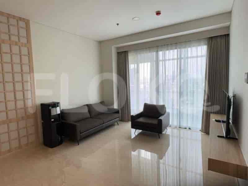 A modern living room with a grey sofa, armchair, and water dispenser.