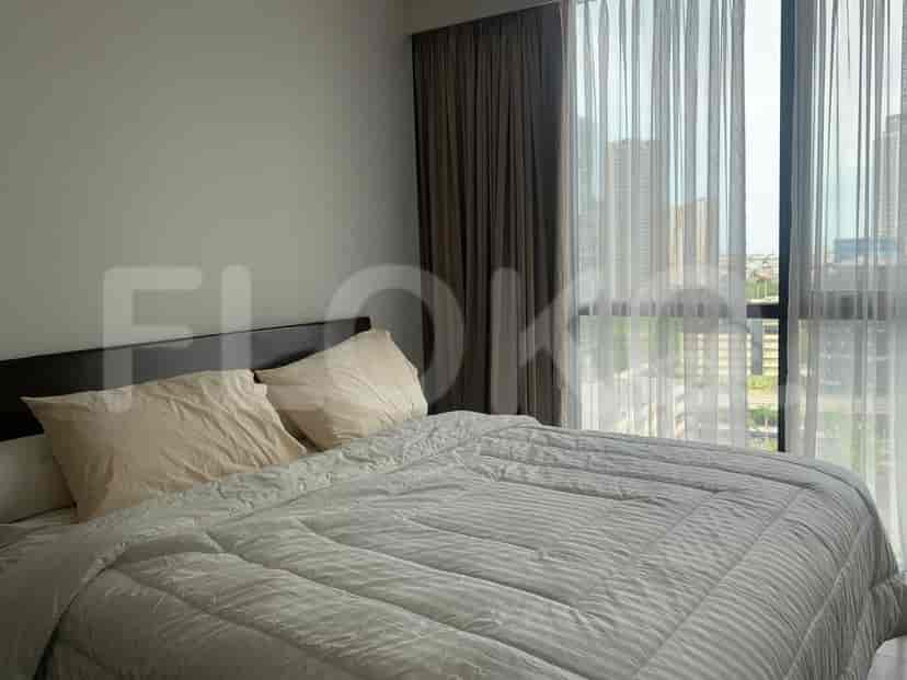 A cozy bedroom with a large bed and a window offering a city view.