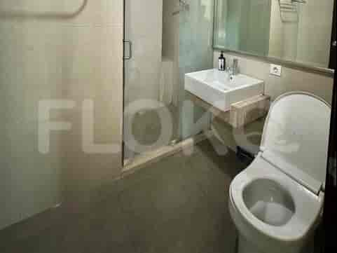 Kamar mandi yang menampilkan toilet, wastafel, dan pancuran kaca.