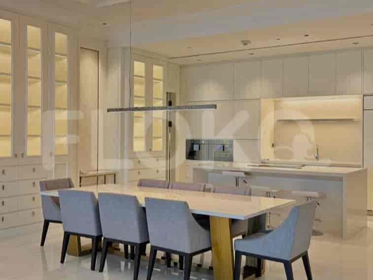 A dining area with a large dining table and chairs, adjacent to a modern kitchen with an island.