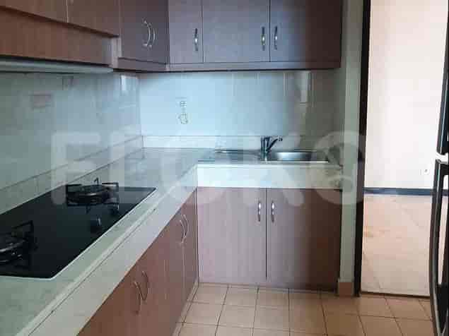 A kitchen with a stove, cabinets, and a sink.