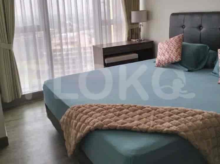 Kamar tidur dengan tempat tidur besar, nakas, dan lampu, dengan jendela besar.