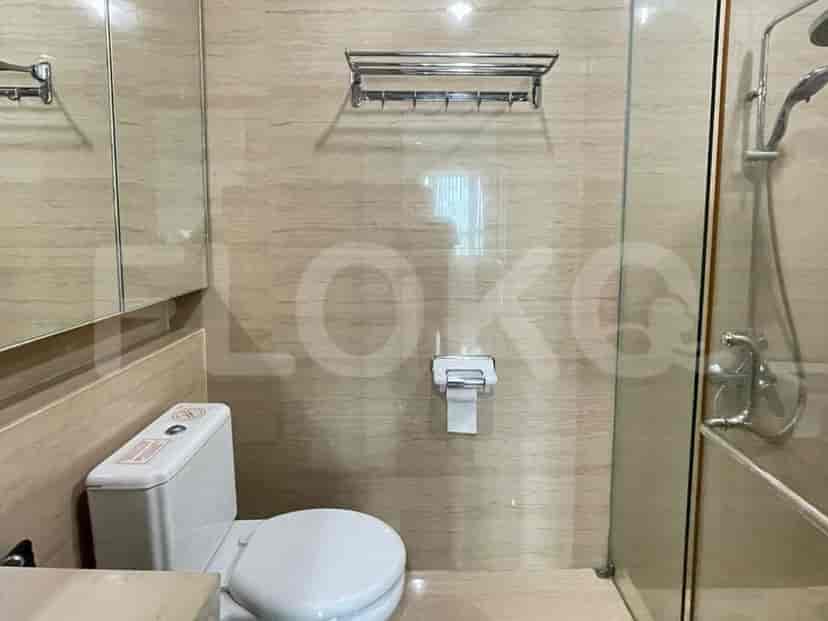 A well-appointed bathroom featuring a shower, toilet, and mounted towel rack.