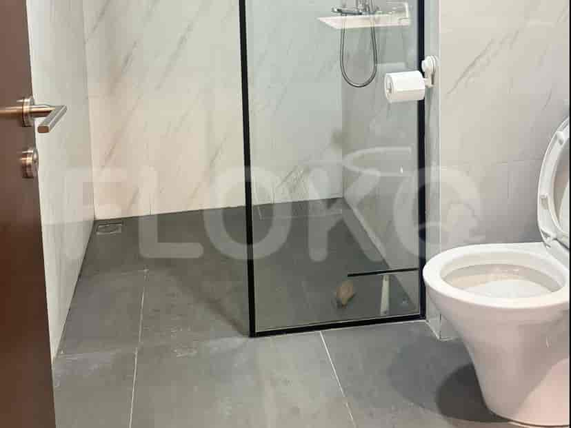A modern bathroom with a glass shower and toilet.