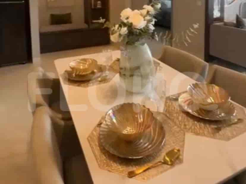 A dining area with a white rectangular table, upholstered chairs, and a decorative floral arrangement.