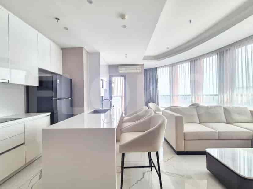 A modern open-plan living and dining area with a sleek kitchen island, comfortable seating, and a dining table.