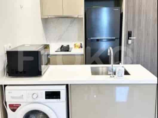 Dapur ringkas dengan microwave, kompor, kulkas, wastafel, dan mesin cuci terintegrasi.