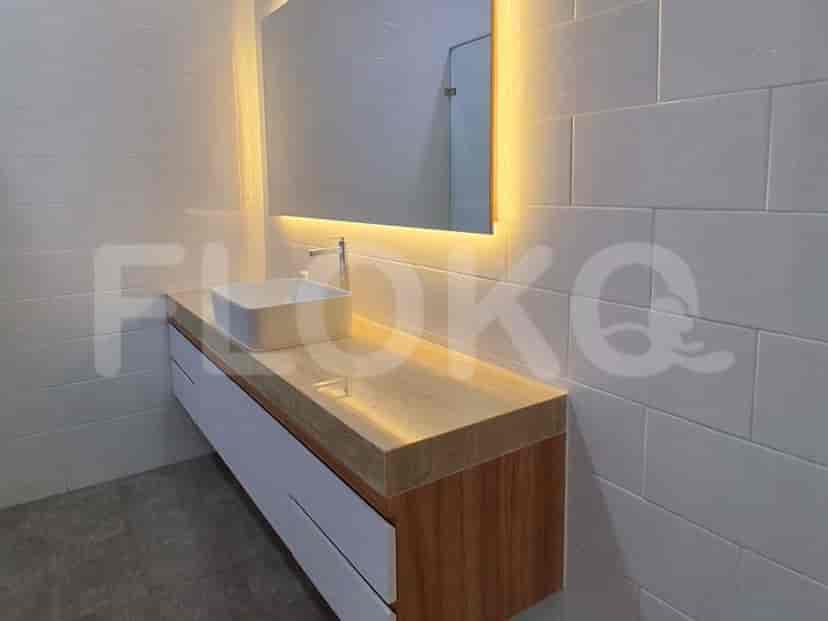A modern bathroom vanity with a white vessel sink, wooden countertop, and backlit mirror.