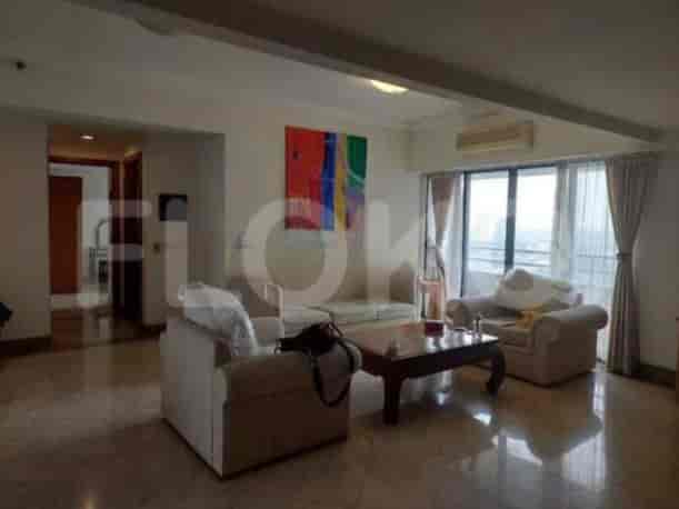 A living room with two sofas, a coffee table, and a colorful painting on the wall.