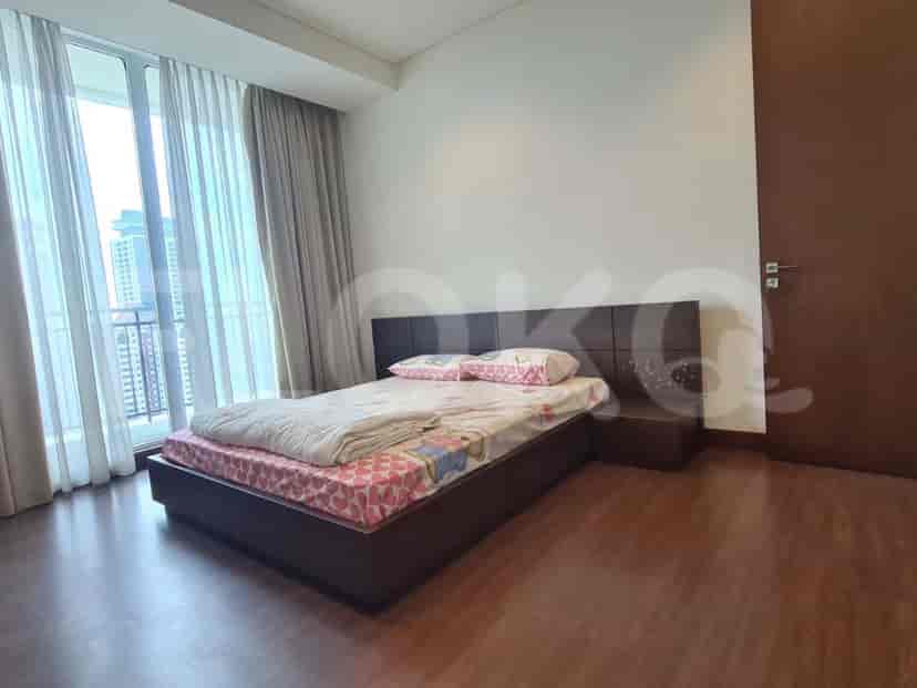 Kamar tidur modern dengan tempat tidur besar, gorden, dan jendela dengan pemandangan kota.