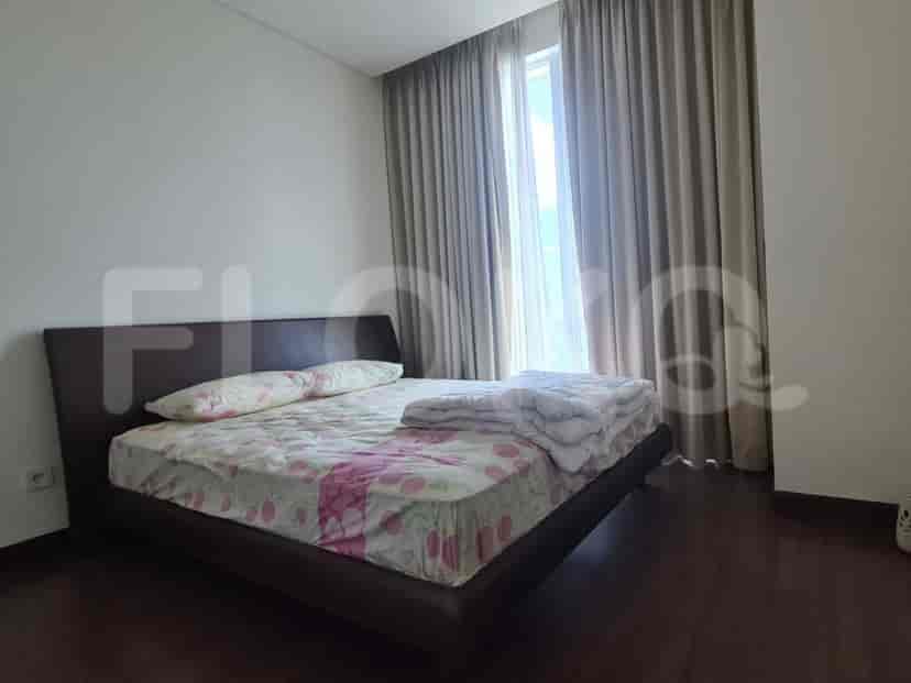 Kamar tidur dengan tempat tidur ganda, gorden, dan jendela, menciptakan suasana yang hangat dan mengundang.