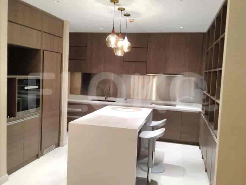 A modern kitchen with sleek wooden cabinetry, a central island with bar stools, and pendant lights.