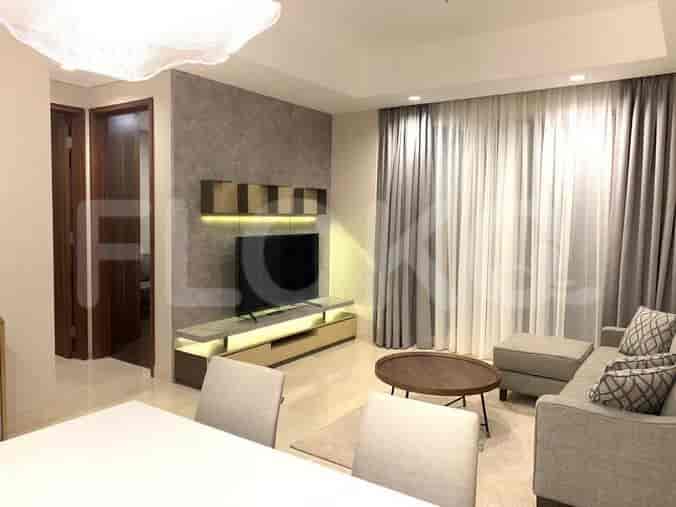 A different angle of the living room showing the TV, sofa, and curtains.