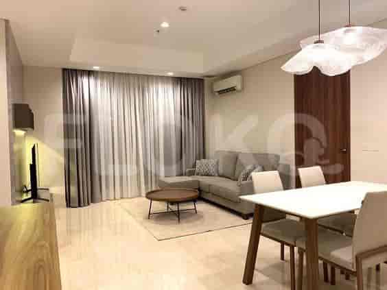 Spacious living room with L-shaped grey sofa, TV, and dining area.