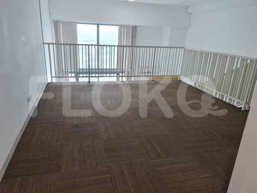 A loft area with carpeted flooring and a white railing.