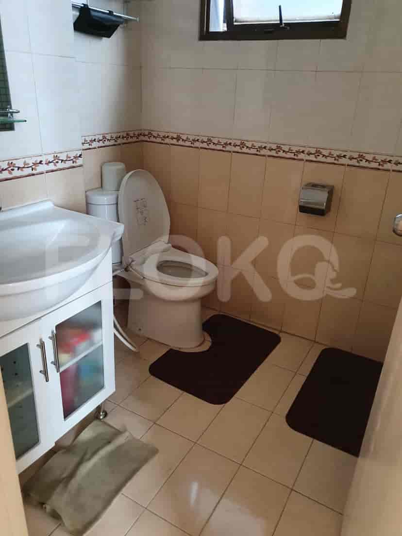 Bathroom with a toilet, sink, and various toiletries.