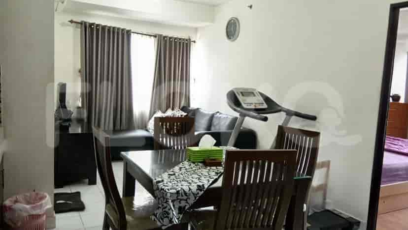 Combined living and dining space with a table, sofa, and treadmill.