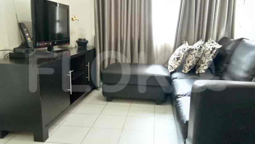 Living room with a black sofa, TV, and black cabinet.