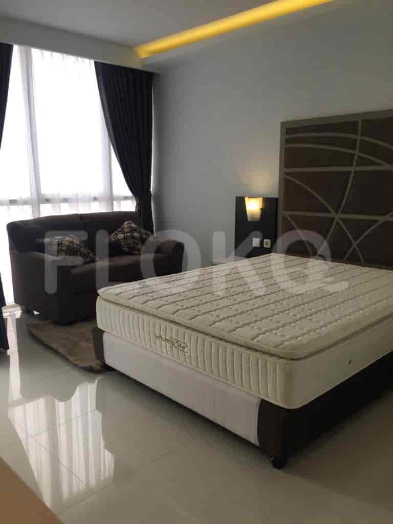 Kamar tidur dengan tempat tidur, sofa, dan jendela.