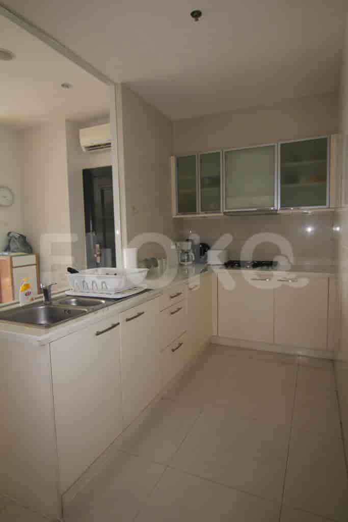 Compact kitchen with white cabinets, sink, and appliances.
