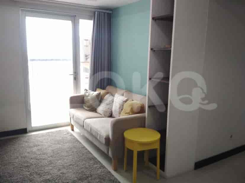 Living room with a sofa, rug, and access to a balcony.