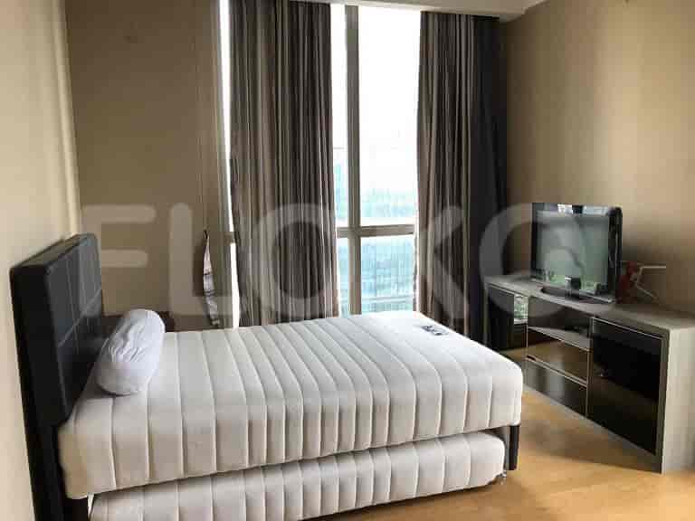 Bedroom with a bed, a TV, and a large window.