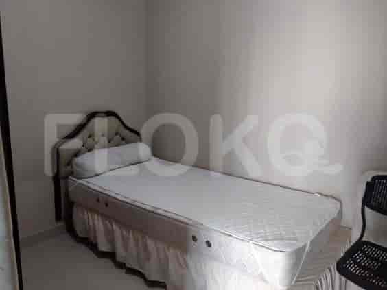 Bedroom with a single bed, a desk and a black chair.