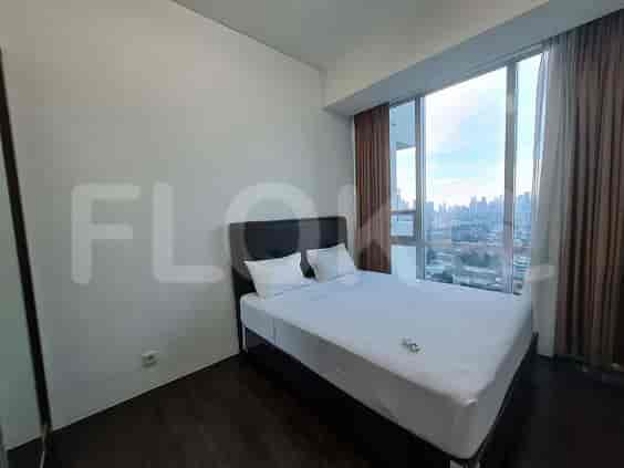 A bedroom with a double bed, large windows with city views.