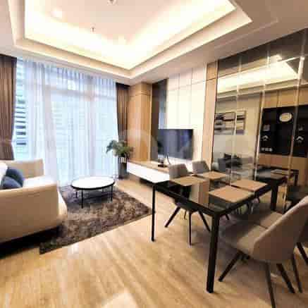 A living room with a dining area and a balcony.